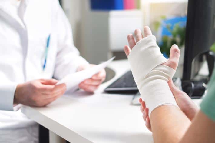 A woman meeting with an attorney after suffering a hand injury in an accident.