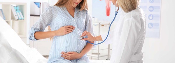 Doctor examines pregnant woman, wrongful birth concept