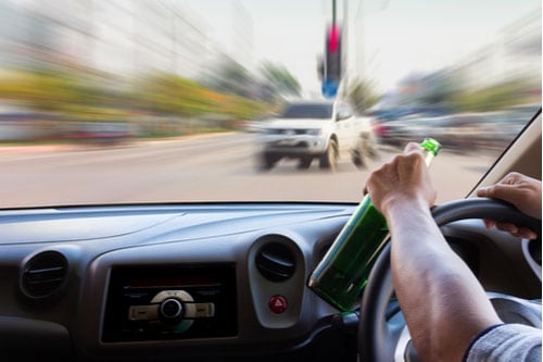 Concept of Laurel drunk driving accident lawyer, man with bottle driving