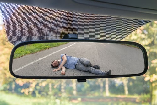 Laurel hit and run accident lawyer concept car mirror view of injured man